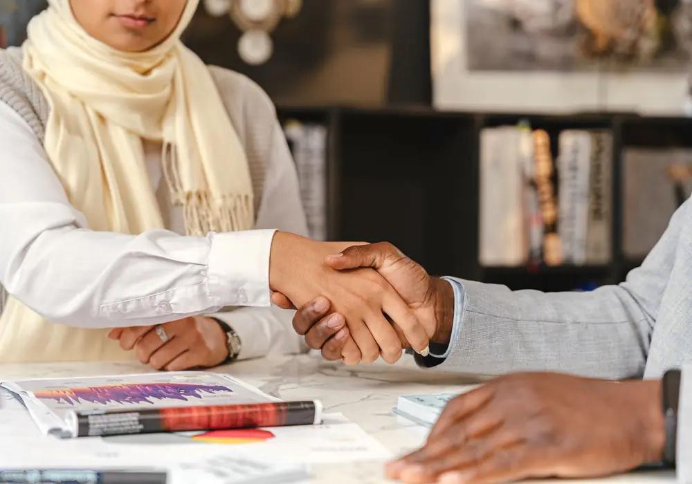 Two people shaking hands across a meeting table (illustrative image, not the business for sale)
